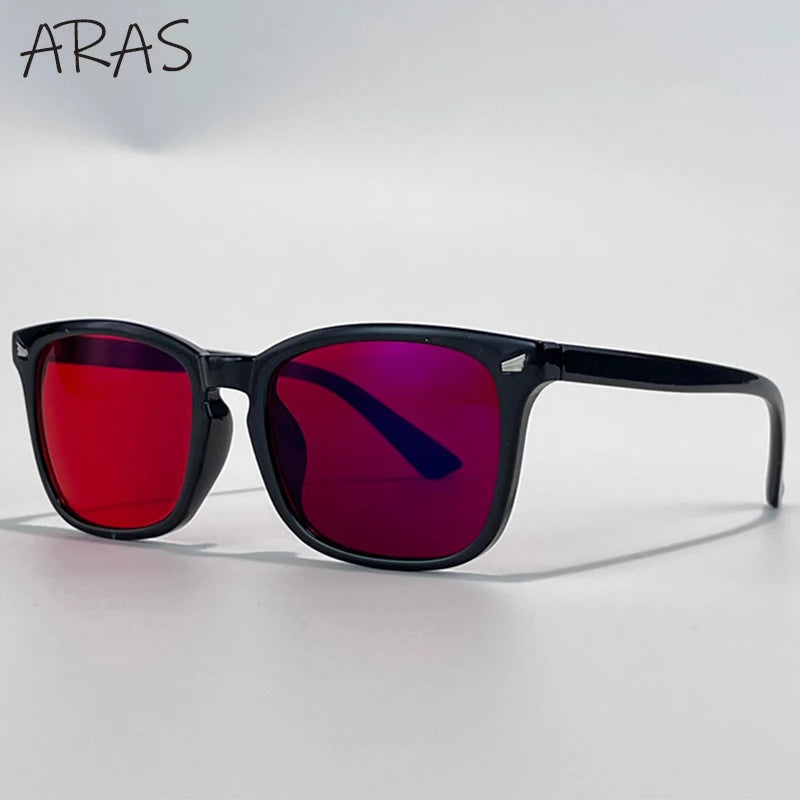 A pair of black anti-blue light glasses with vibrant purple and red lenses resting on a white surface.
