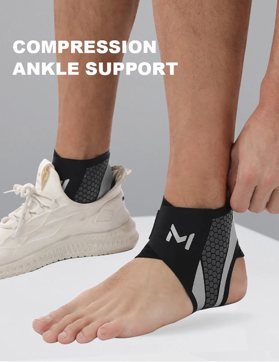 Person trägt einen schwarzen Kompressionsknöchelhalter am Fuß und Knöchel neben einem weißen Schuh.