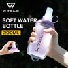 A hand holds a purple soft water bottle with a clear liquid, demonstrating its use for outdoor activities.