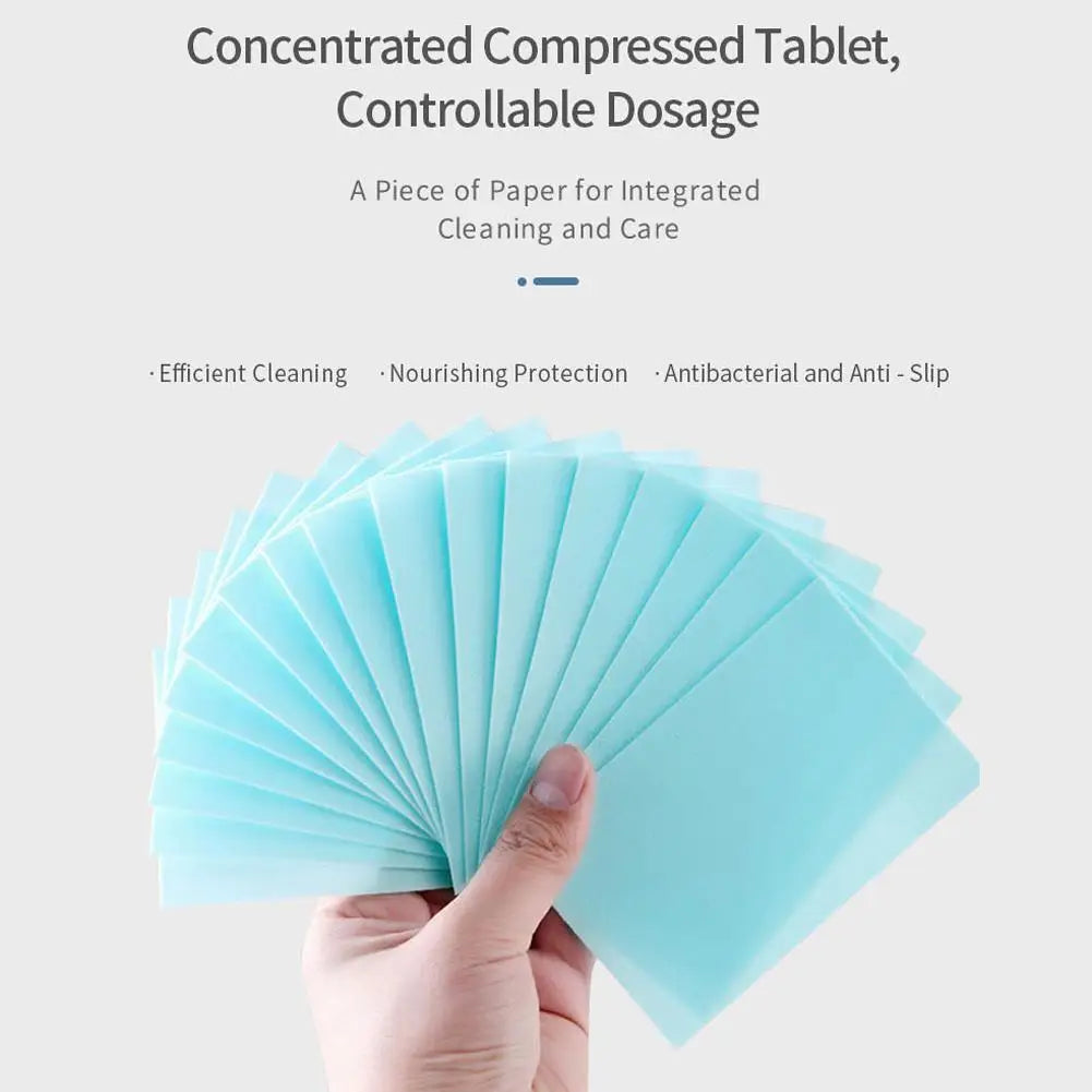 A hand holds a fan of light blue compressed tablets for integrated cleaning and care.