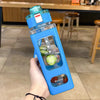 A hand holds a blue leakproof sport water bottle with time markings and a green liquid inside.