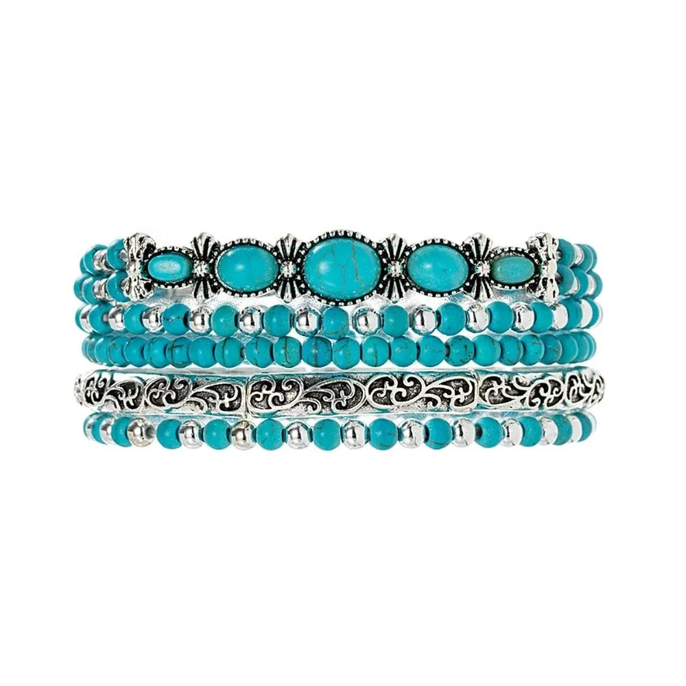 Un set de cinq bracelets perlés avec des pierres turquoise et du métal argenté.
