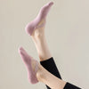Primer plano del pie de una persona usando calcetines deportivos rosas ajustados para yoga y pilates.