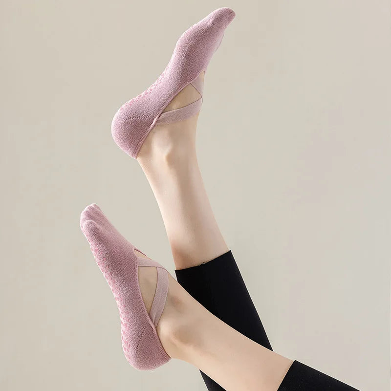 Primer plano del pie de una persona usando calcetines deportivos rosas ajustados para yoga y pilates.