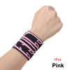 Pink adjustable wrist support brace worn on a hand and wrist.