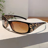 Brown tinted sunglasses with black frames featuring gold and floral rhinestone detailing.