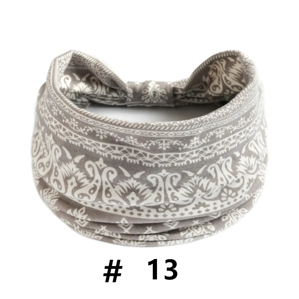 A gray knitted headband with an intricate geometric pattern is shown.