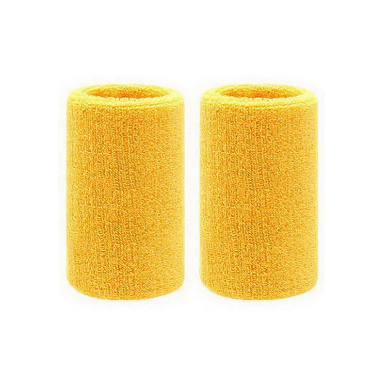 A pair of bright yellow dual sports wristbands for sweat absorption.