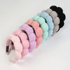 A set of colorful microfiber skincare headbands and wristbands in pastel shades and black.