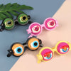 A collection of colorful novelty glasses featuring hearts and various eye designs on a light background.