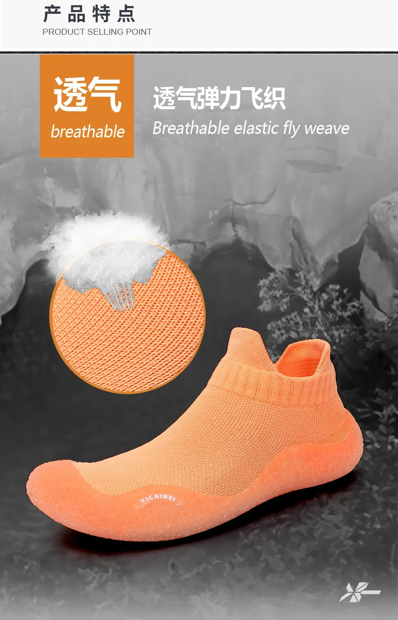 An orange breathable elastic fly weave slip-on shoe shown against a dark background.