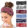 A woman wearing a purple bohemian print wide headband with various paisley patterns.
