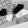 Un paquete de calcetines deportivos en colores gris, negro y blanco dispuestos en una cuadrícula.