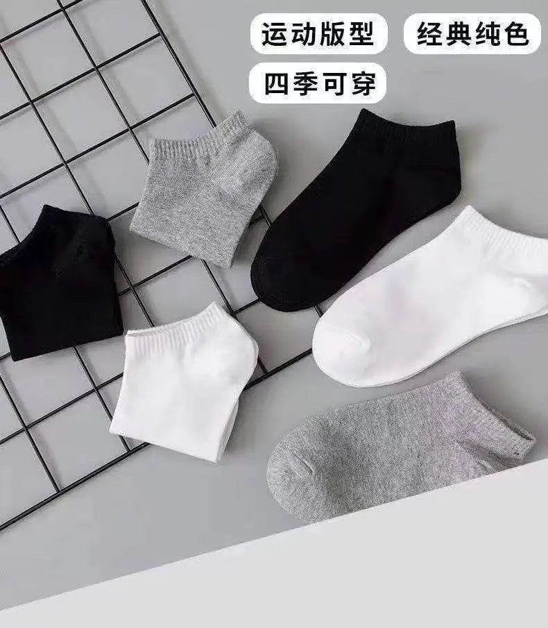 Un paquete de calcetines deportivos en colores gris, negro y blanco dispuestos en una cuadrícula.