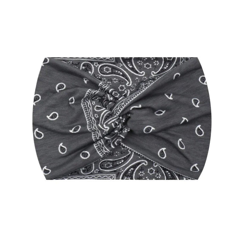 Bandeau de sport gris foncé à imprimé, noué avec des motifs paisley blancs.