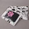 A pair of black thigh-high socks featuring a repeating cat motif and a pink paw print design.