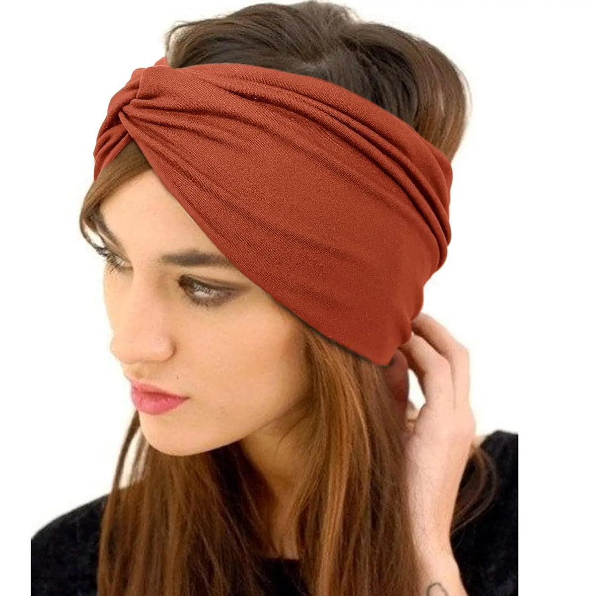 Una mujer lleva una diadema bohemia ancha de color terracota envuelta en su cabello.