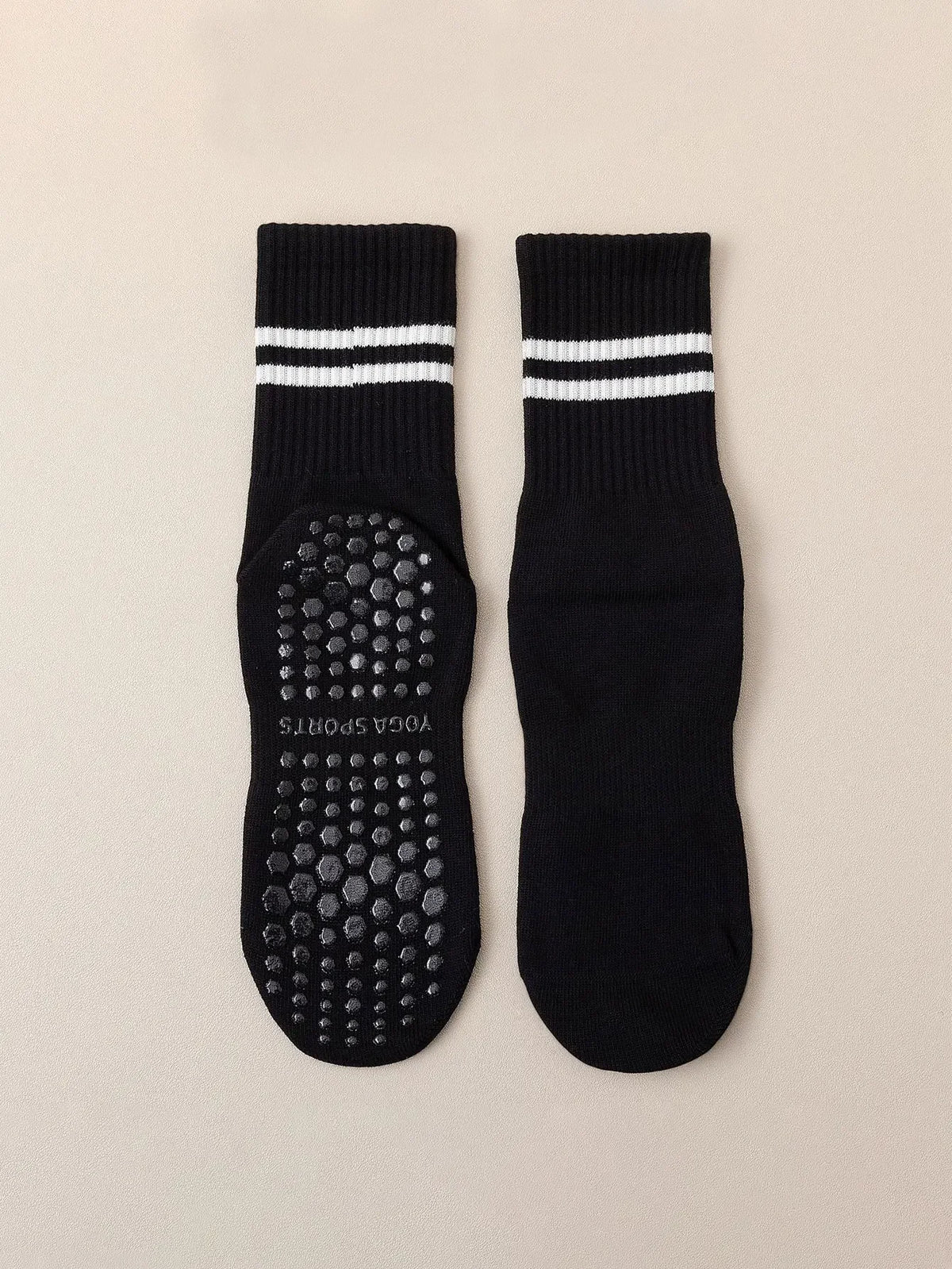 Pair of black grip socks with white stripes and a textured sole for yoga and barre
