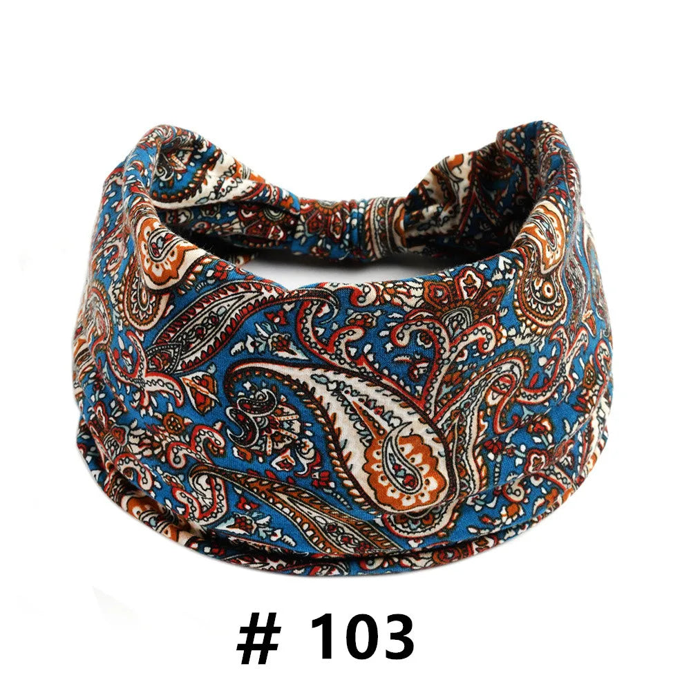 A close-up of a blue and orange boho print cotton headband for hair or workout.