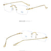 Gold-toned frameless rectangle glasses with clear lenses shown in a studio setting.