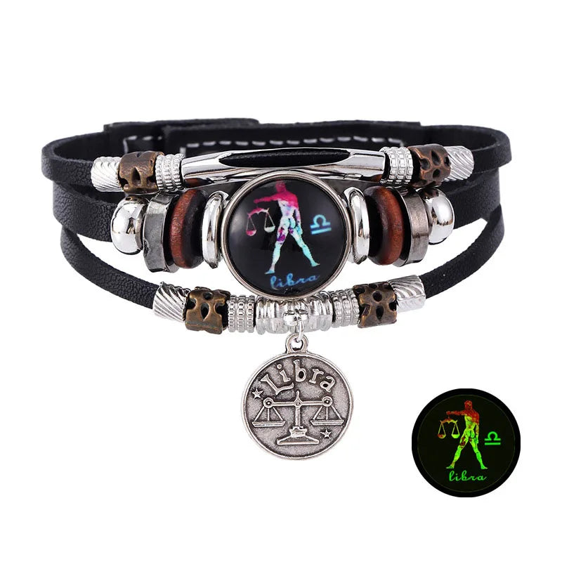 Pulsera de cuero plateado y oscuro con un dije de Libra, que presenta balanzas y la constelación de Libra.