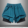 A pair of teal athletic shorts with black trim and a black liner displayed flat.
