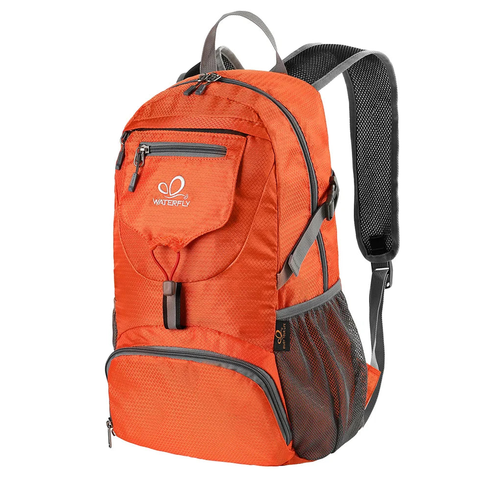 An orange ultra-light foldable travel backpack with gray accents and black straps.