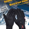 Une paire de gants d'exploration imperméables noirs contre un fond de montagne enneigée.