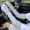 A person wearing white long-sleeved shirts is holding a steering wheel inside a car, demonstrating UV protection arm sleeves.