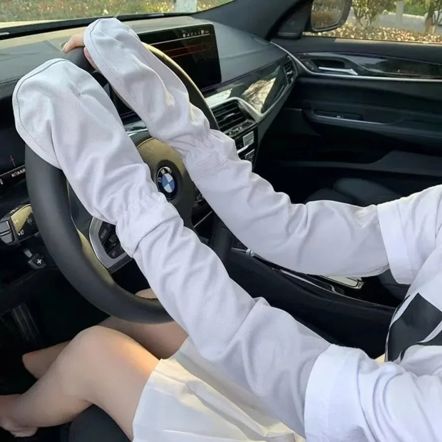 A person wearing white long-sleeved shirts is holding a steering wheel inside a car, demonstrating UV protection arm sleeves.