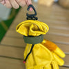 A yellow tactical nylon glove with a black hook attached, being held by a hand.