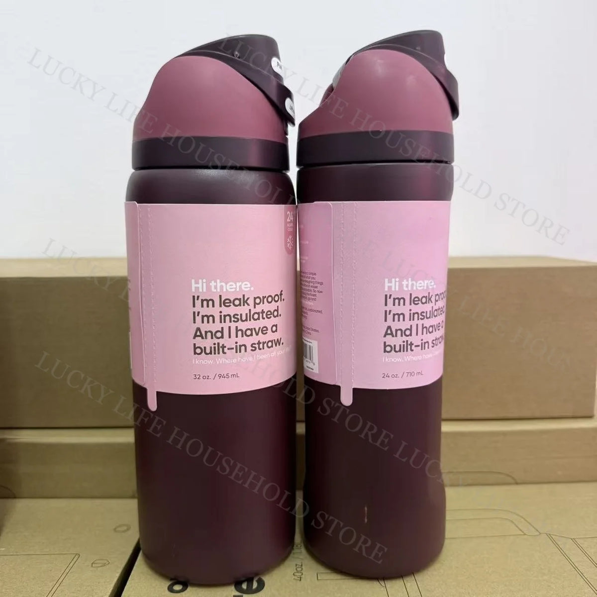 A pair of purple insulated stainless steel sports water bottles standing upright in a cardboard box.