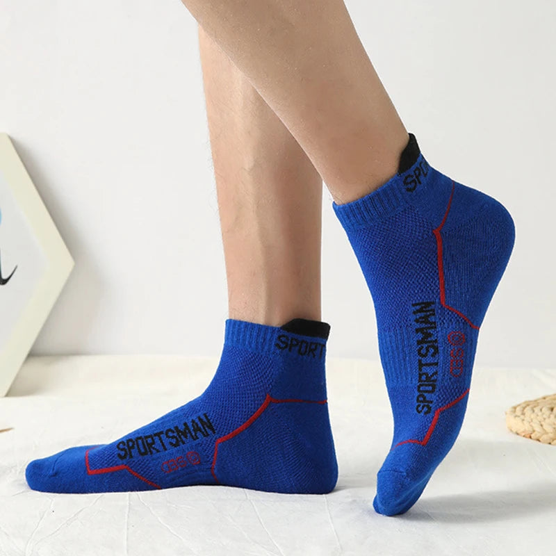 A close-up of a pair of royal blue men's athletic socks with red stitching and the Sportsman logo