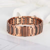 A close-up of a rose gold copper bracelet with magnetic clasps resting on a white surface.