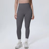 A model wearing high-waisted gray quick-drying yoga and fitness leggings and white sneakers.
