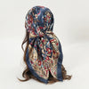 Elegant satin square scarf featuring a dark blue background with intricate floral and paisley patterns