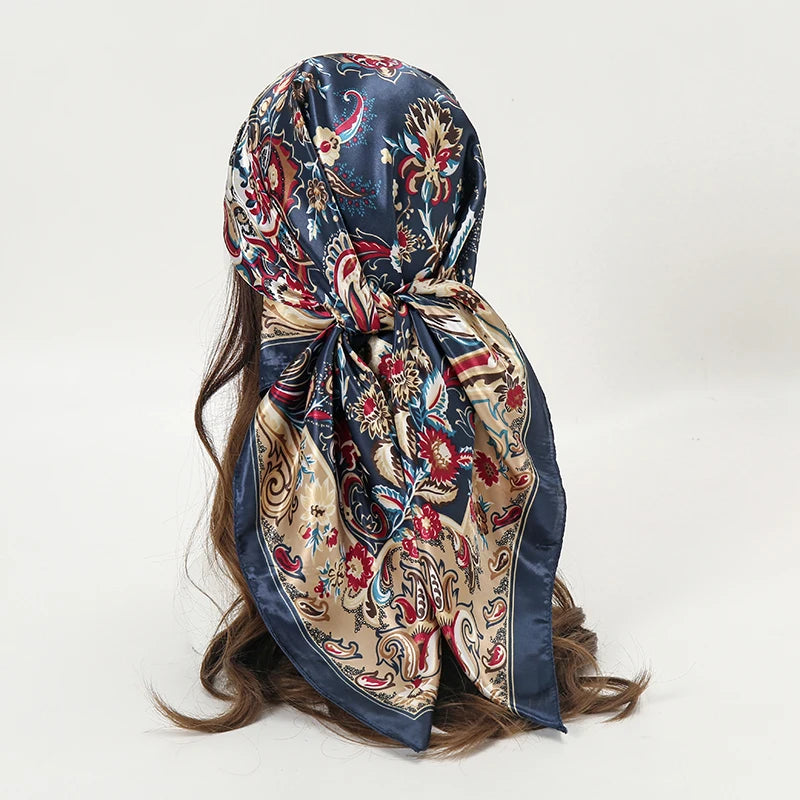 Elegant satin square scarf featuring a dark blue background with intricate floral and paisley patterns