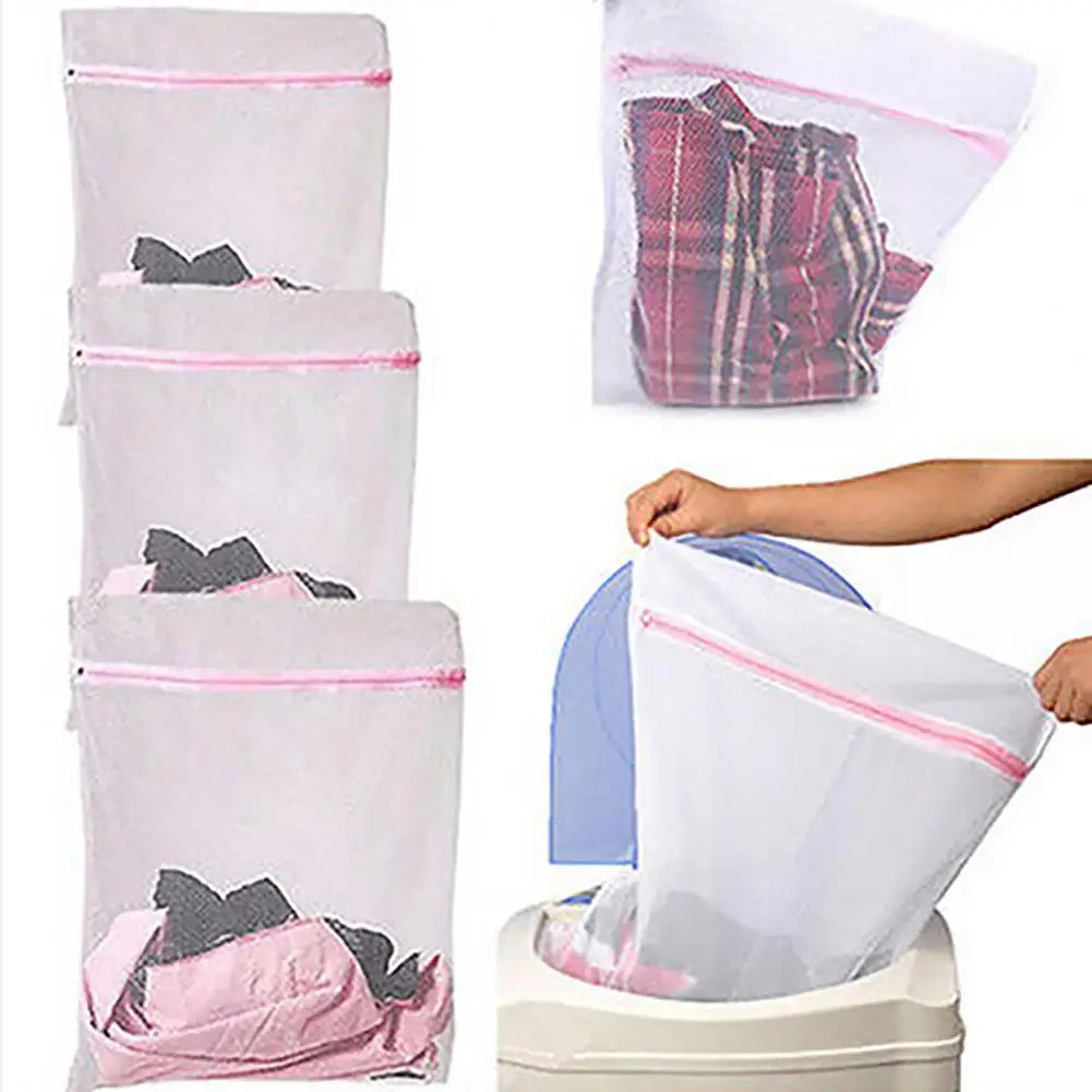 Un juego de bolsas organizadoras de ropa de malla duraderas en tela rosa y blanca, algunas llenas de ropa.