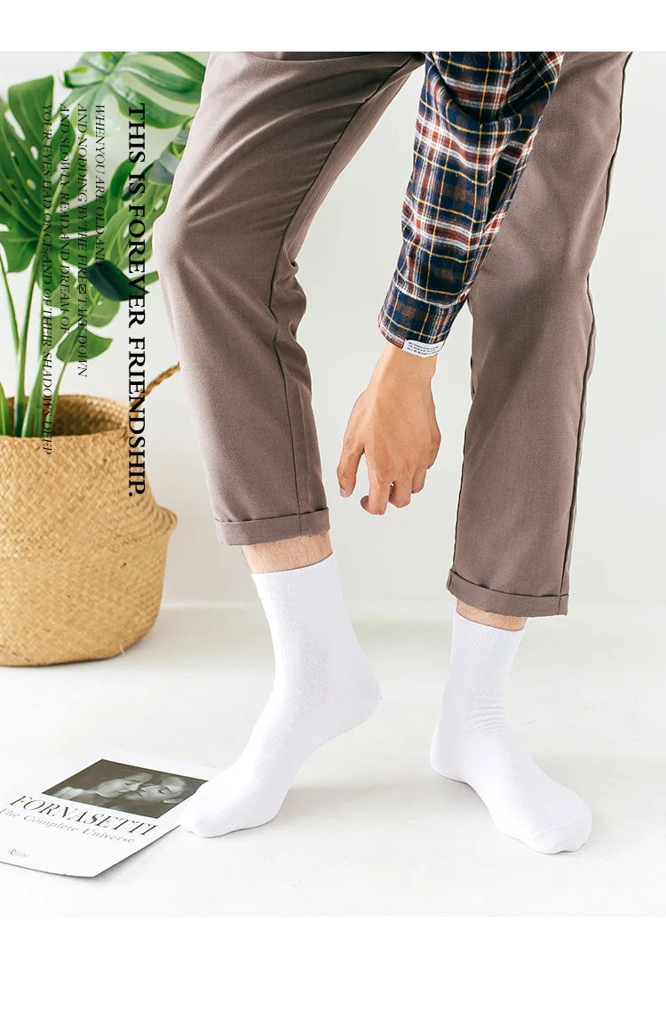Vue de dos d'une personne portant un pantalon marron et une chemise à carreaux, avec des chaussettes blanches de type crew.