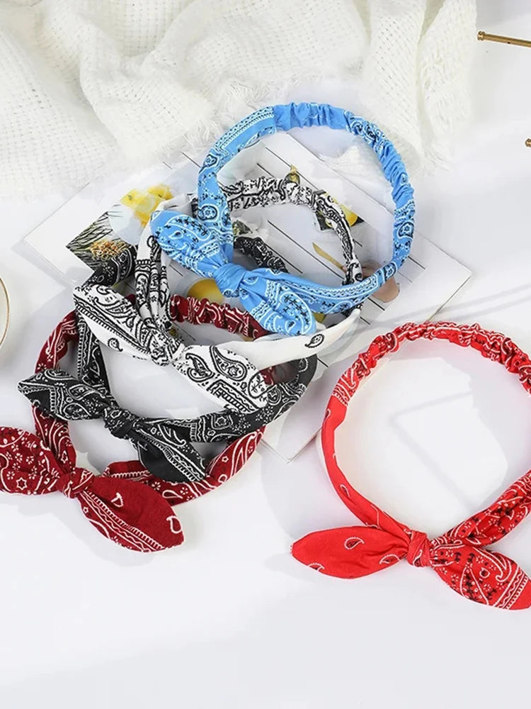 A collection of boho paisley elastic hair headbands in black, white, and blue are displayed on a white background.