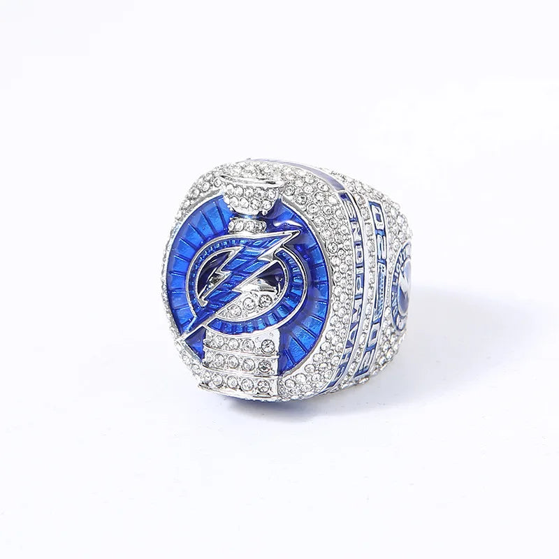 A close-up of a pair of championship rings featuring blue enamel and pave diamonds.
