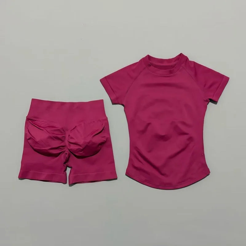 A magenta seamless yoga set for women featuring a short sleeve top and matching workout leggings.