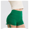 A person is wearing bright green performance yoga shorts, highlighting a small waistline.