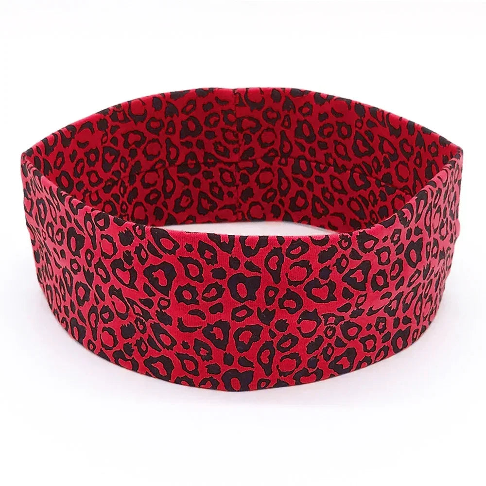A red leopard print women's sports headband shown flat.