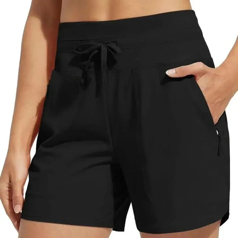 Black high-waisted quick-dry athletic shorts with a drawstring waist shown on a model.