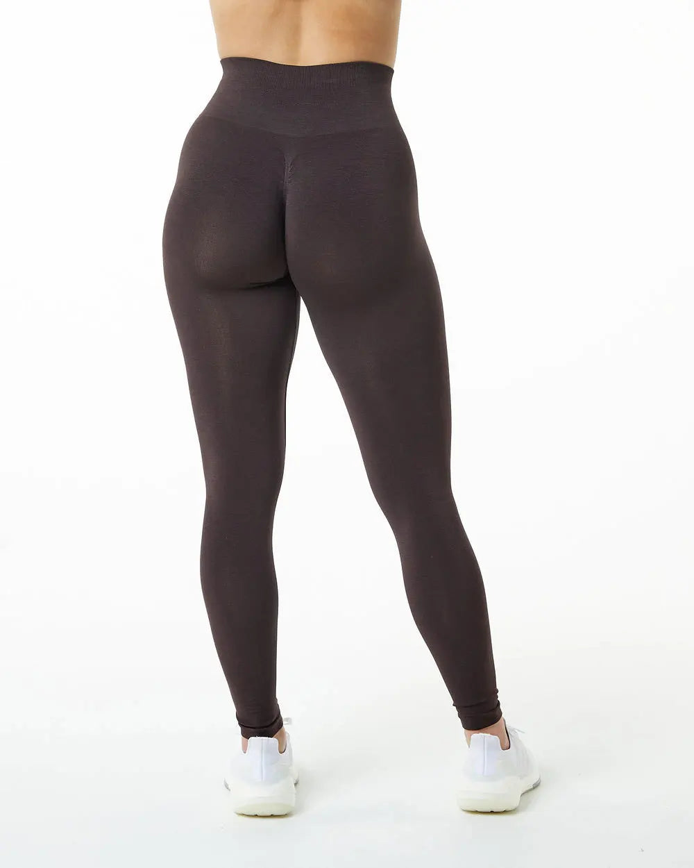 Un mannequin porte des leggings de yoga sans couture à taille haute de couleur brun foncé.