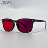 A pair of black sunglasses with red and purple mirrored lenses resting on a white surface.