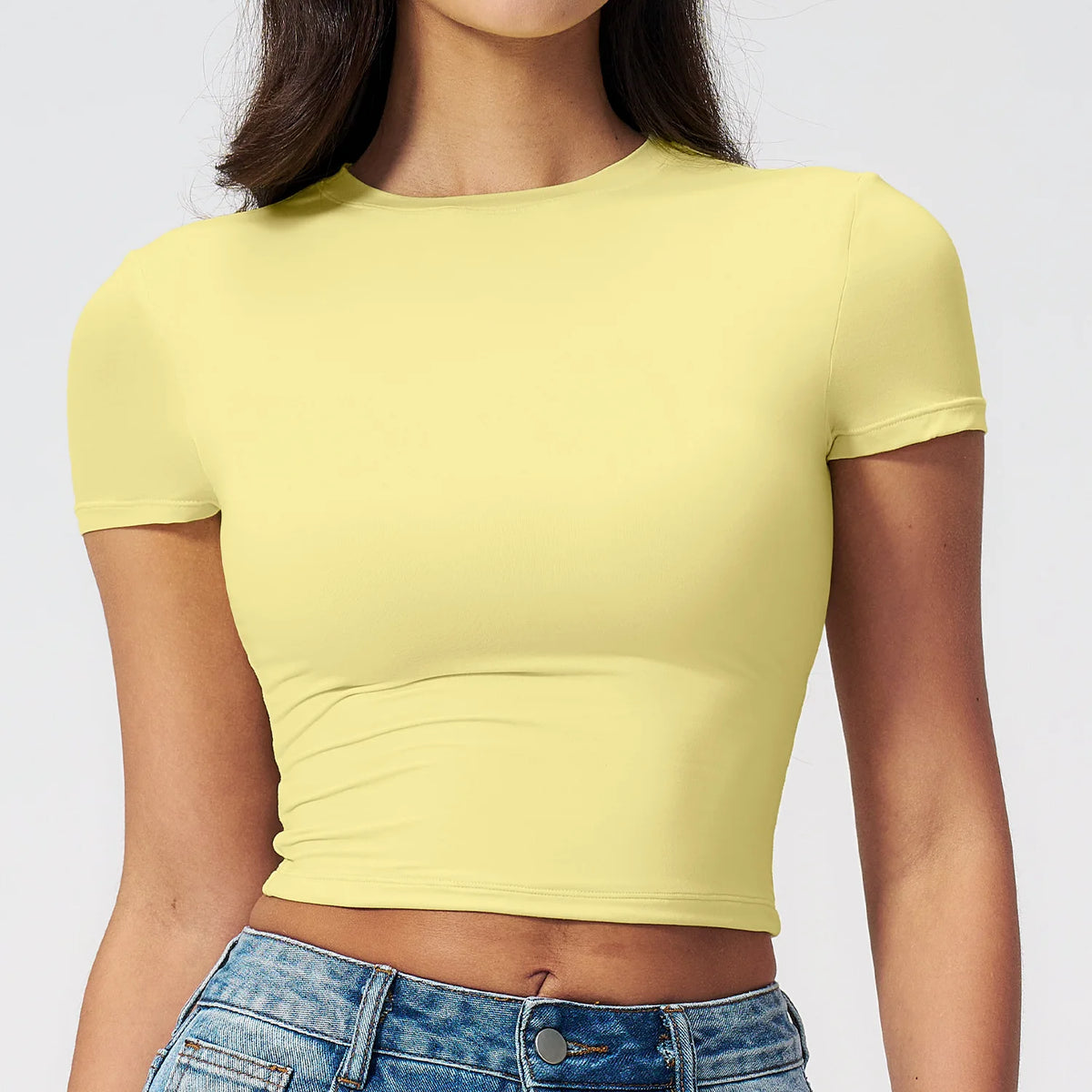 Camiseta amarilla de yoga y fitness de secado rápido usada por una mujer.