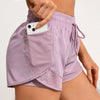 A close-up of a purple athletic short featuring mesh pockets and drawstring details.