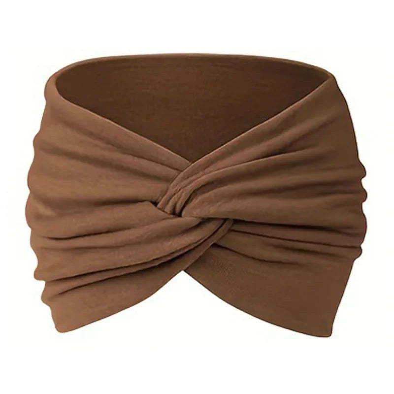 A brown stretch sport headband is shown folded and wrapped around itself.
